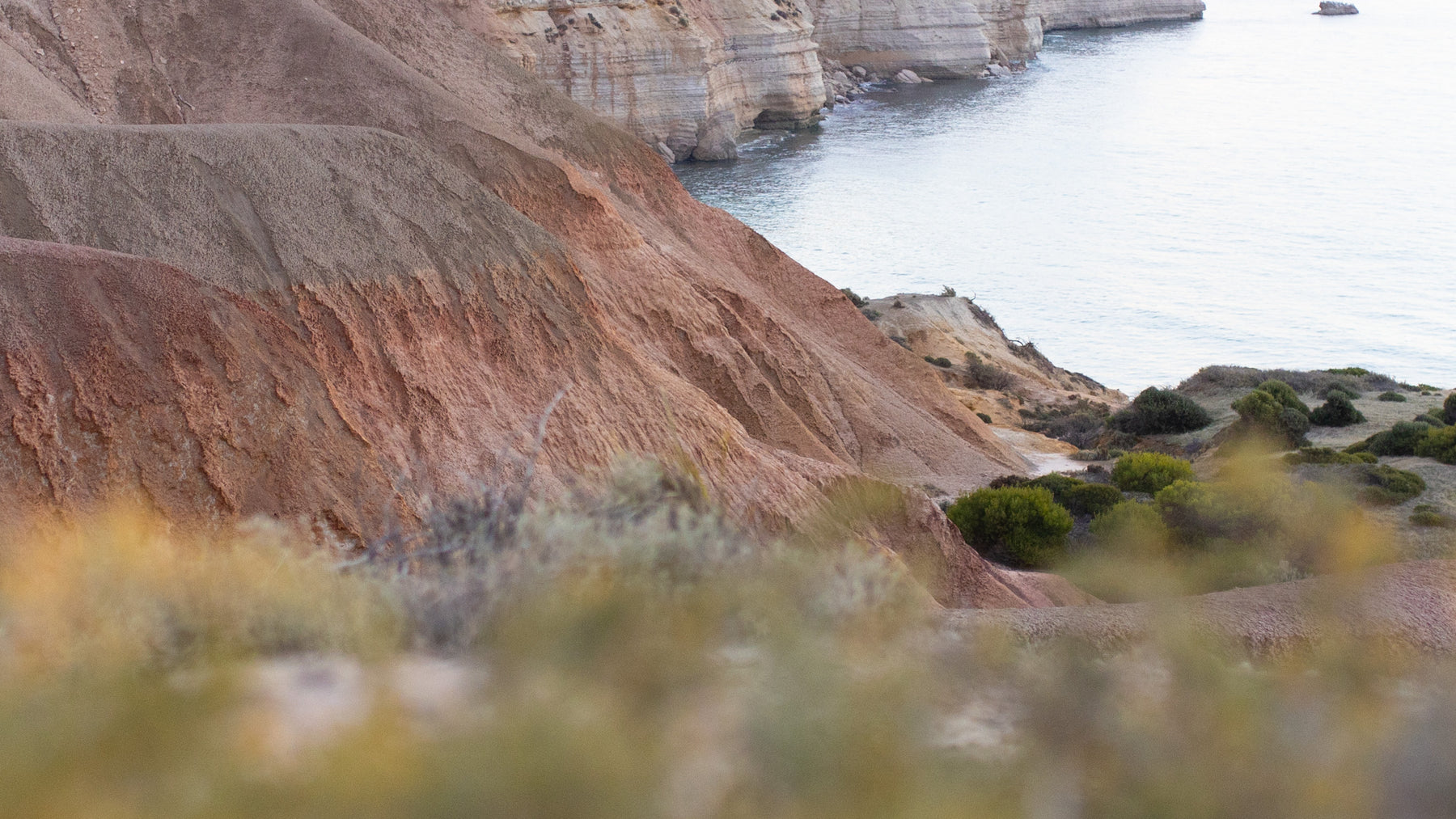 Coastal location with ochre earth cliffs and the sea in the distance